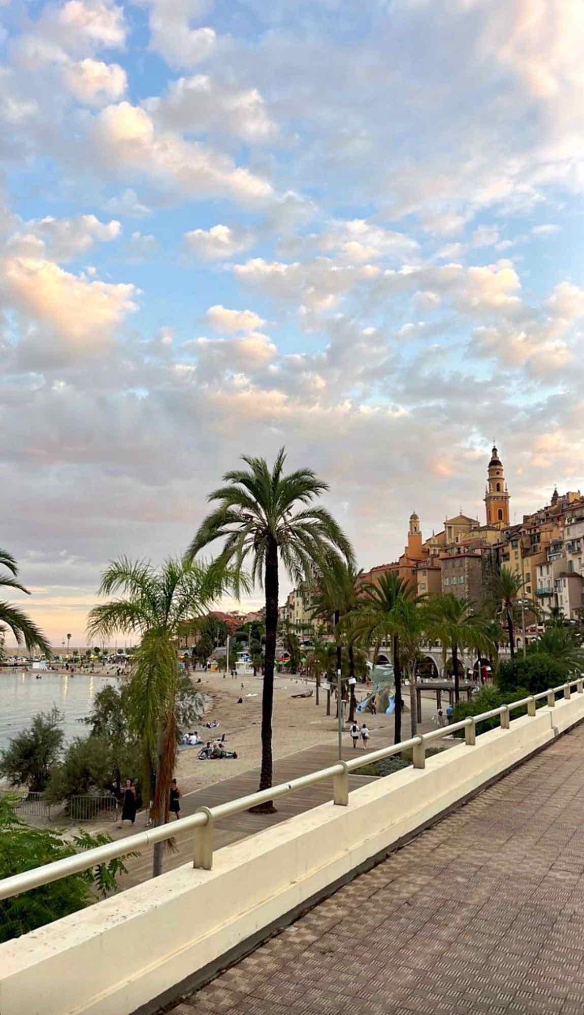 Promenade du bord de mer de Menton, palmiers et basilique Saint-Michel